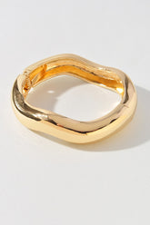 Gold sculptural bracelet with square rounded edges and glossy finish