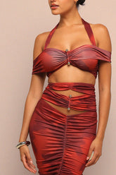 Red ruched dress worn by a model on a beige background