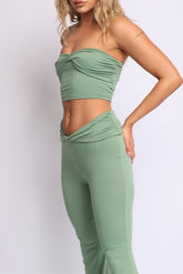 Sage green two-piece set with twisted tube top and low rise flared pants