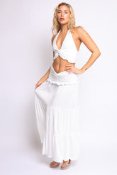 White halter crop top with twist-front detail and matching low-rise tiered skirt