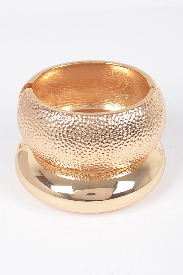 Gold hammered bangle with domed shape and textured metallic finish

