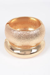 Gold hammered bangle with domed shape and textured metallic finish

