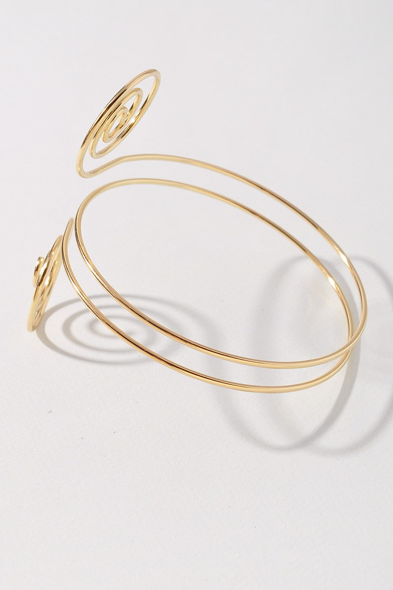 Gold spiral wire arm cuff with double swirl design and open wrap fit

