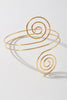 Hypnotic gold arm cuff featuring symmetrical swirl ends and open back

