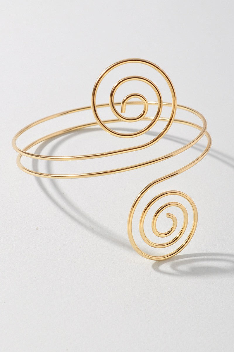 Hypnotic gold arm cuff featuring symmetrical swirl ends and open back

