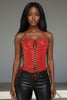 Model wearing a red lace-up top and black leather pants against a neutral background