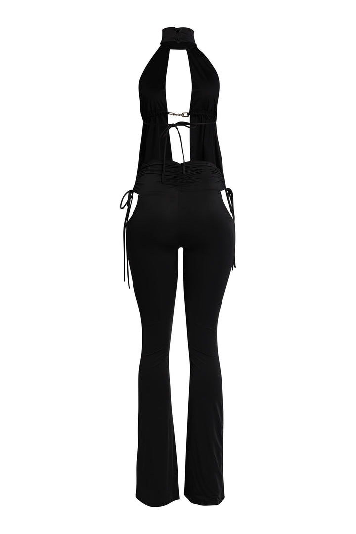 Rear view of black flare pant set with fitted silhouette and open-back halter

