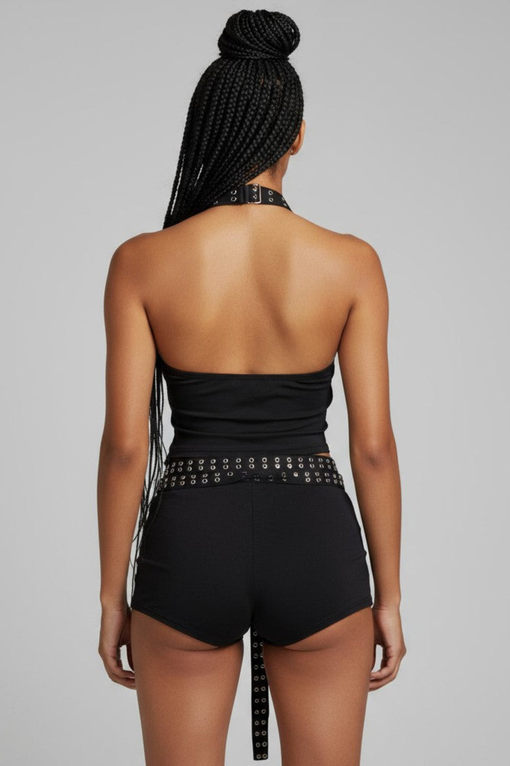 Person wearing a black outfit with white accents on a gray background