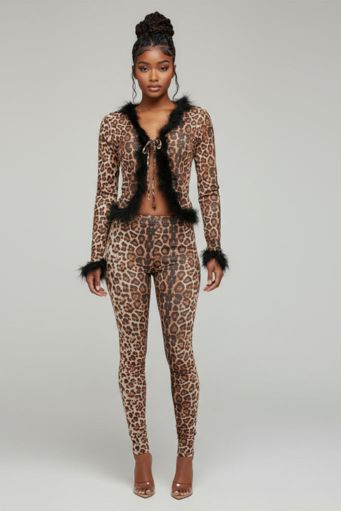 Model wearing a leopard print outfit with black fur trim on a gray background