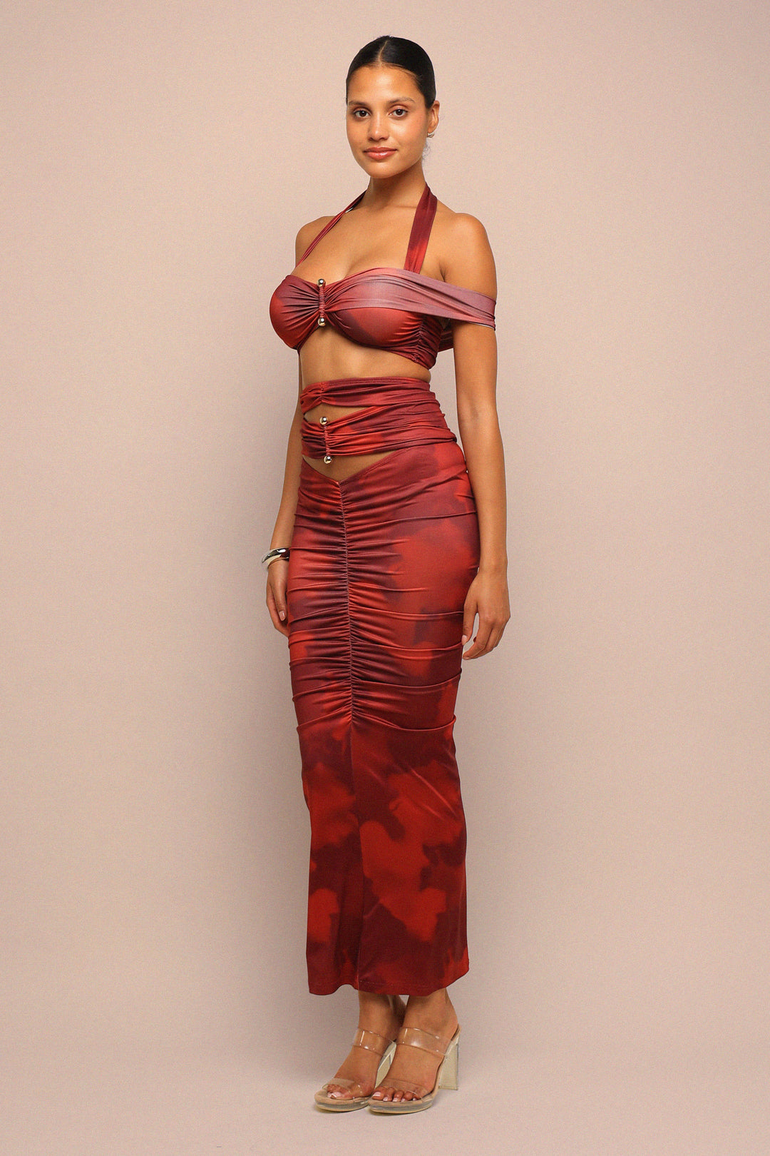 Woman wearing a red patterned dress against a beige background