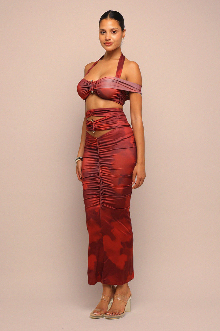 Woman wearing a red patterned dress against a beige background