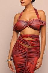 Red ruched dress worn by a model on a beige background