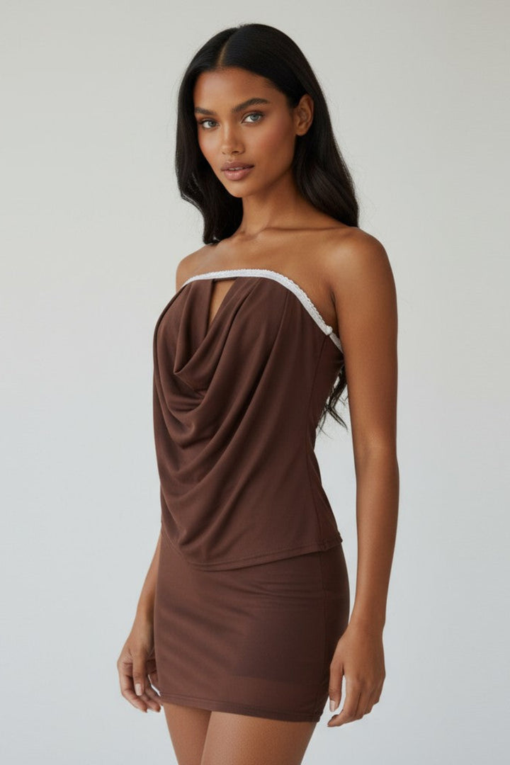 Woman wearing a brown off-shoulder dress against a plain background