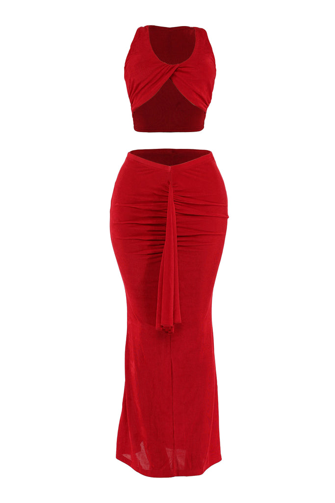Front angled view of red ruched maxi set with twist front top and bold drape detail