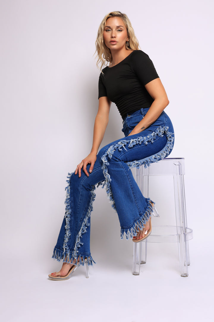 Distressed fringe denim flared pant.