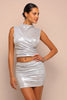 Woman wearing a silver metallic dress against a beige background