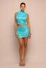 Woman wearing a turquoise outfit against a beige background