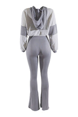 Gray and white outfit with a cropped top and flared pants on a white background