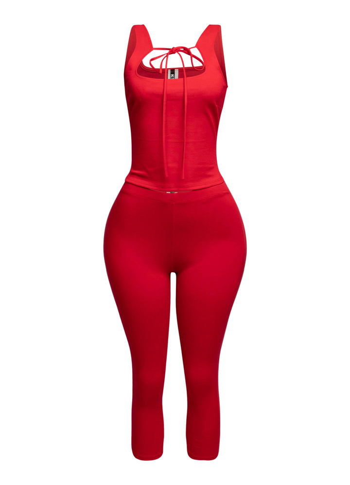 Vibrant red tank top with a chic tie-front detail, paired with fitted capri pants for a bold and playful look.