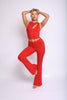 Bold red flare pant set with asymmetrical neckline crop top and curve-hugging slim fit

