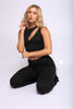 Minimal black two-piece with asymmetrical shoulder detail and sculpted flare-leg silhouette


