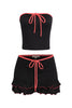 Black contrast trim mini skirt set with hot pink piping, tie-front tube top, and flared ruffle hem