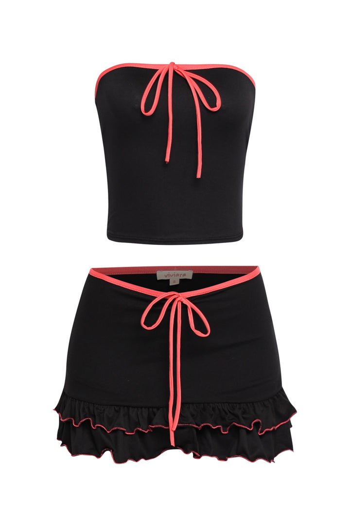 Black contrast trim mini skirt set with hot pink piping, tie-front tube top, and flared ruffle hem