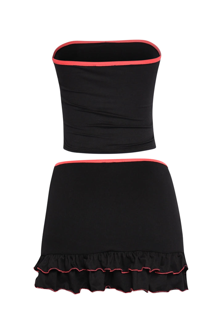 Black bodycon two-piece with neon pink edges, stretchy tube top, and midrise skirt with playful hemline