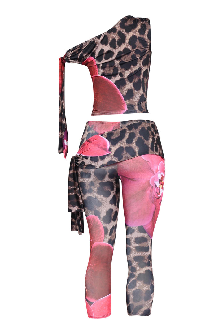 Asymmetrical pink two-piece with sleeveless crop top and vibrant capri bottoms

