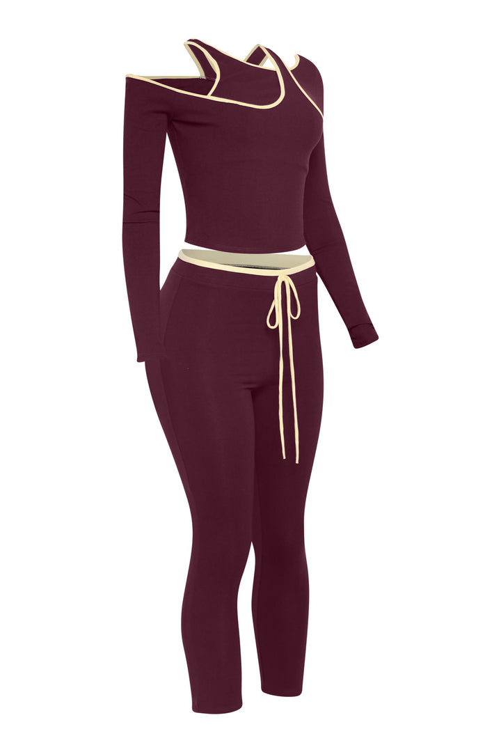 Right angle showing wine red matching set with fitted pants and asymmetrical top cut