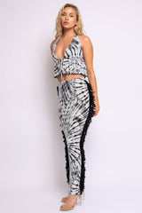 Model wearing backless halter crop top and bodycon midi skirt in black spiral tie-dye

