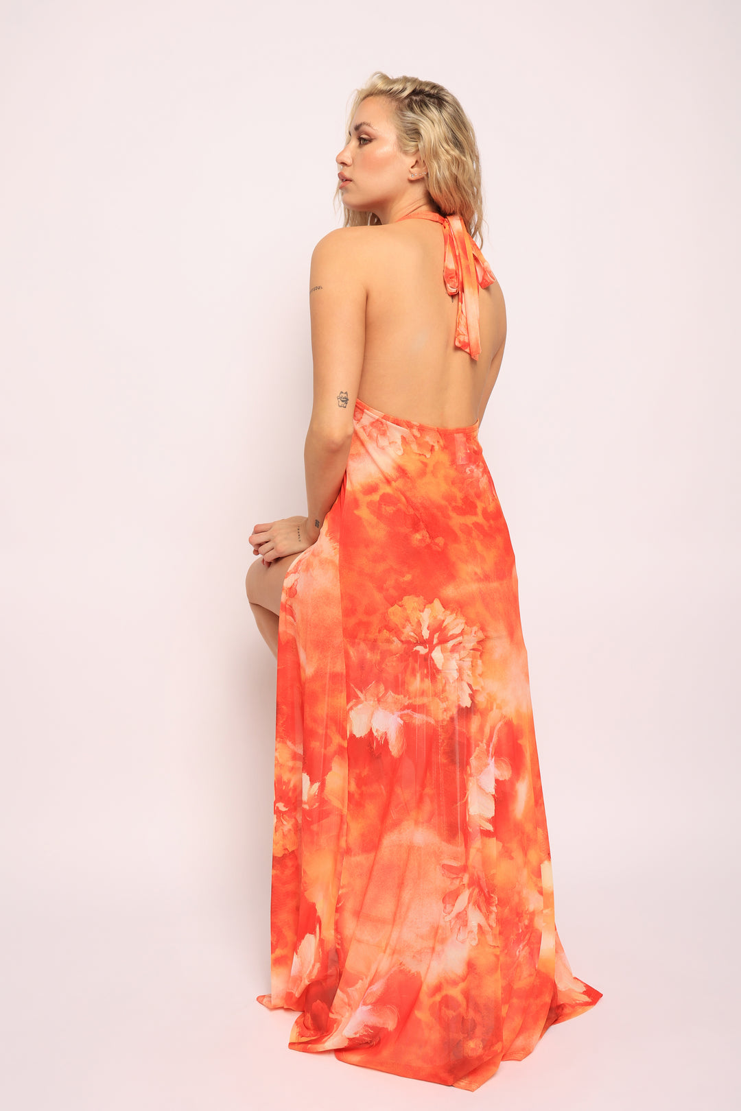 • Sitting pose in orange skirt set showing stretch fabric and layered silhouette

