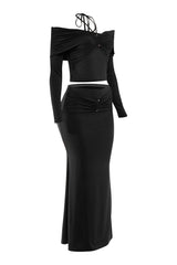 Black two-piece outfit with long sleeves and a skirt on a white background