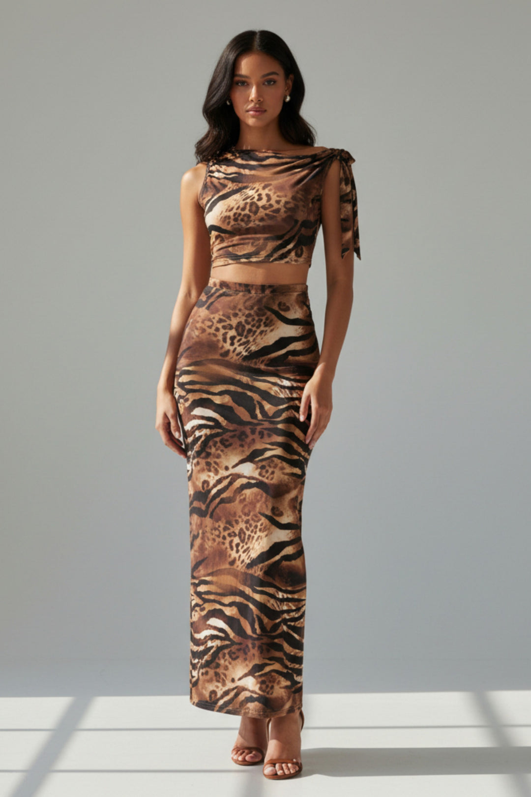 Woman wearing a two-piece animal print outfit on a plain background