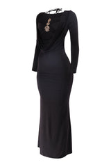 Black long-sleeve dress with embellishments on a white background