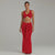Model walking in red twist front two-piece set with ruched maxi skirt and flared hem, showing curve-hugging silhouette and fluid fabric movement