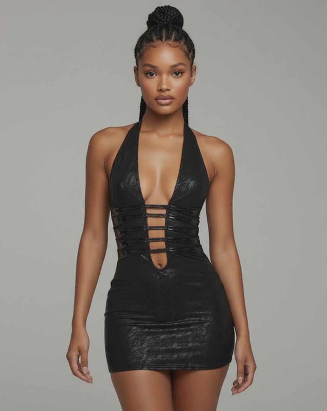 Model walking in black halter mini dress with deep plunge neckline and ladder strap cutouts, highlighting bodycon fit and glossy lace texture