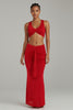 Front angled view of red ruched maxi set with twist front top and bold drape detail
